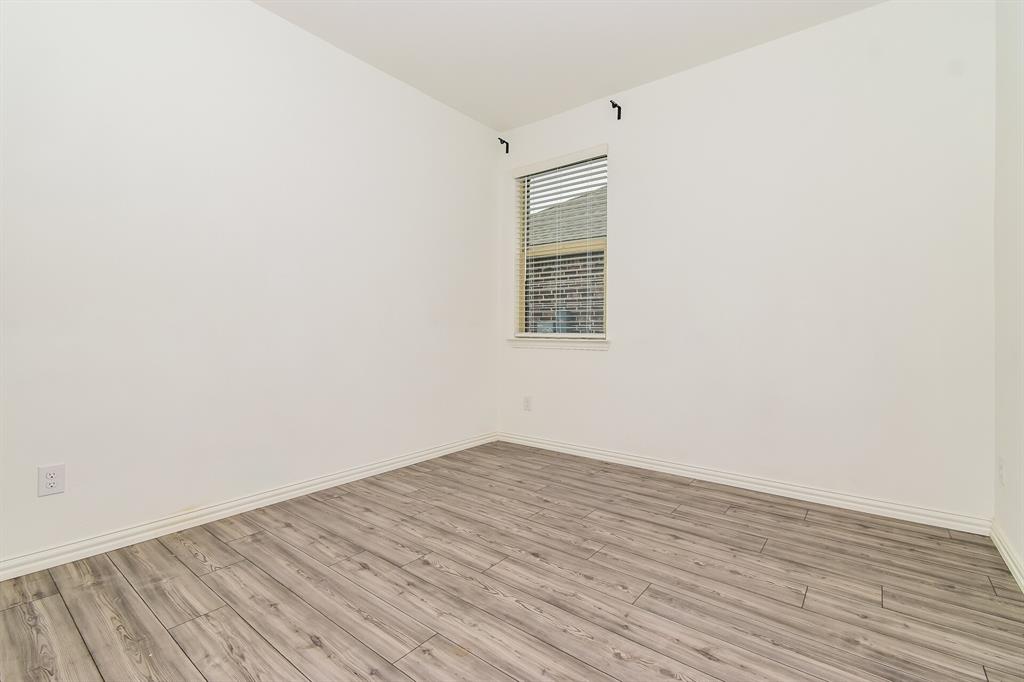 1208 Mesquite Lane Princeton, TX 75407 - Photo 13 of 17 an empty room with wooden floor and windows