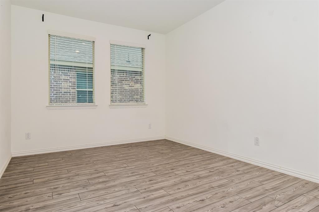 1208 Mesquite Lane Princeton, TX 75407 - Photo 4 of 17 an empty room with wooden floor and windows