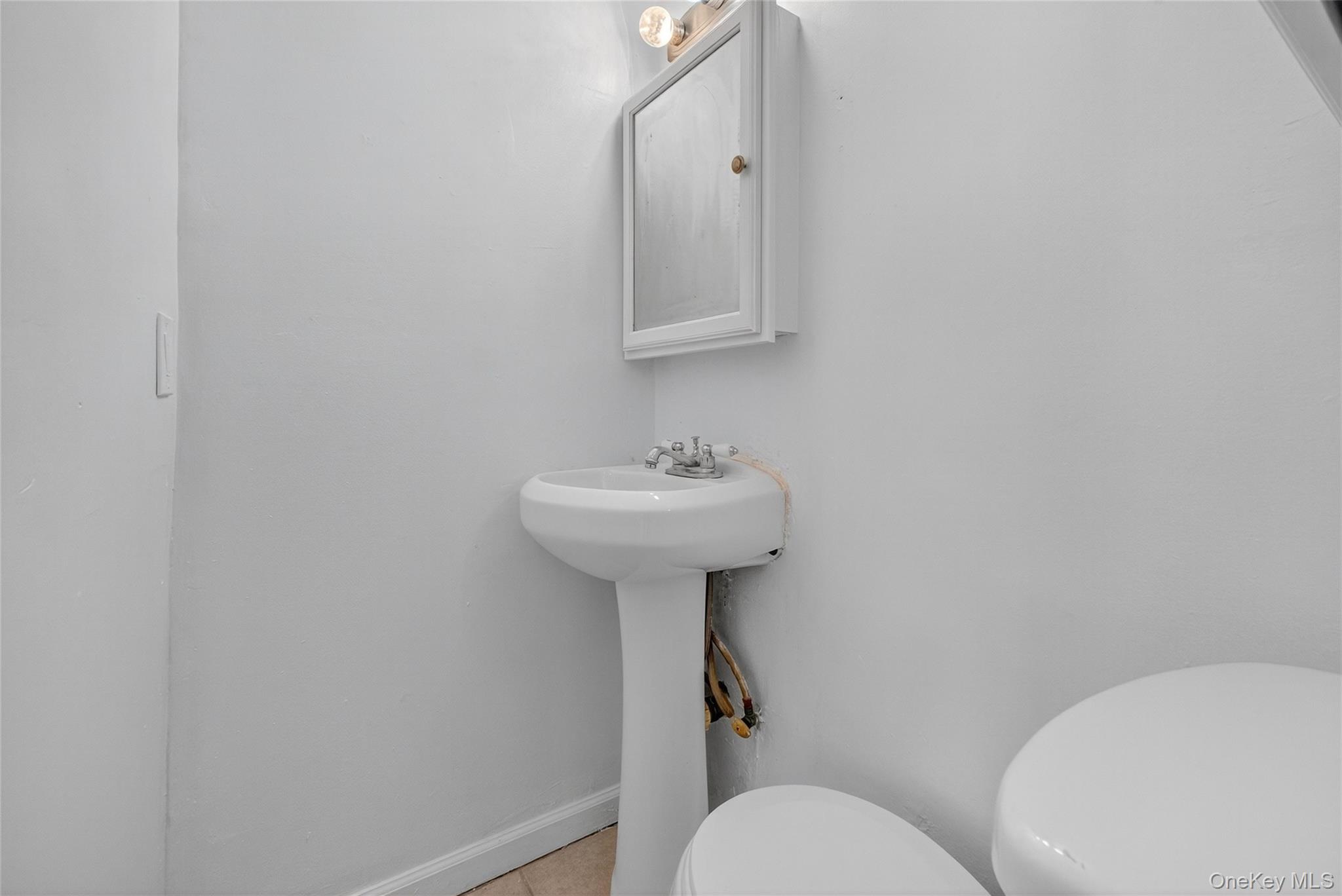49 South Hamilton Street, Unit 2 Poughkeepsie, NY 12601 - Photo 15 of 20 a bathroom with a toilet sink and mirror