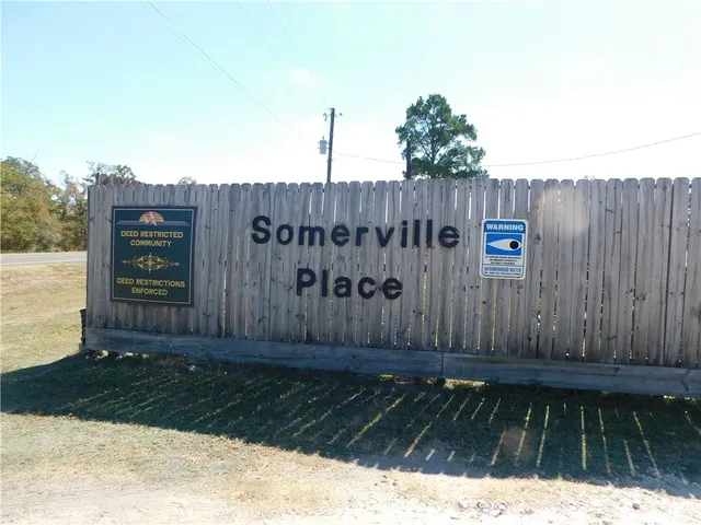 a backyard of a house with table and chairs under an umbrella