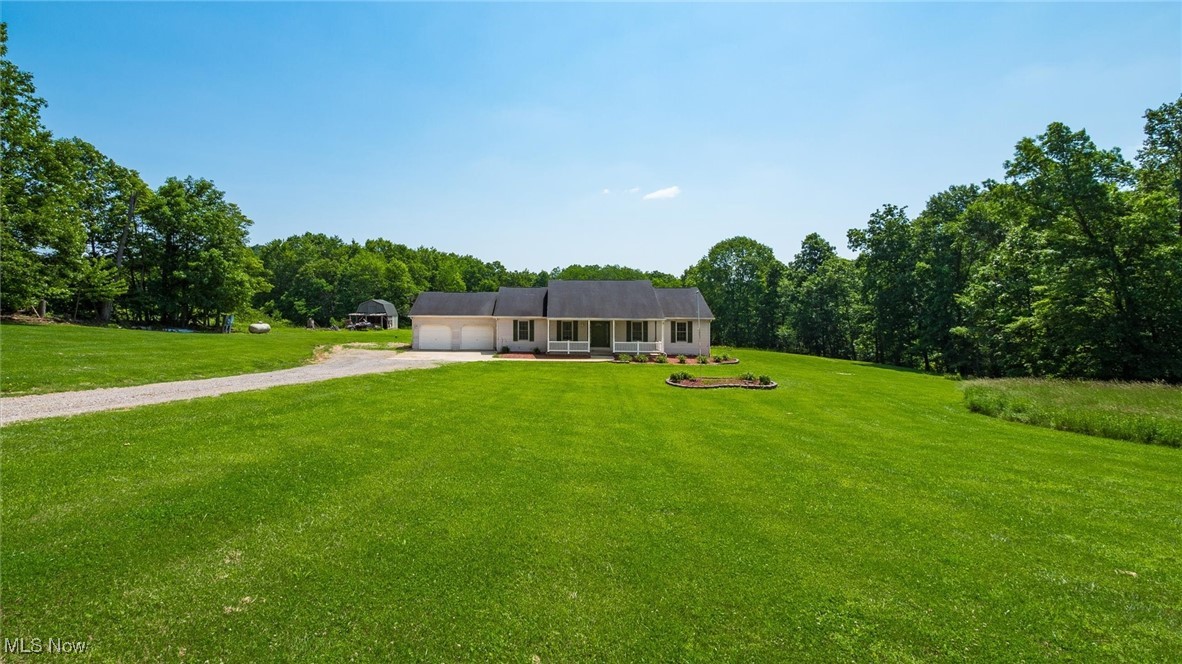 9910 Matchett Road Norwich, OH 43767 - Photo 2 of 48 Ranch-style house featuring dirt driveway, an attached garage, and a front yard