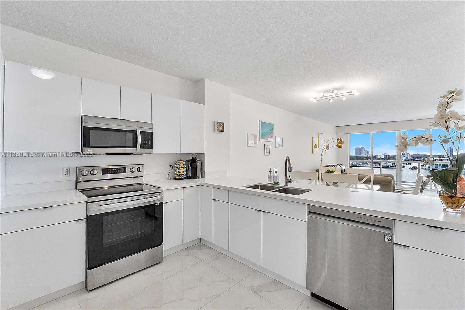 17050 North Bay Road, Unit 807 Sunny Isles Beach, FL 33160 - Photo 11 of 50 a kitchen with sink a microwave and cabinets