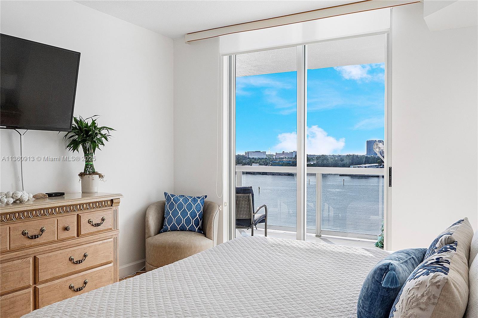 17050 North Bay Road, Unit 807 Sunny Isles Beach, FL 33160 - Photo 16 of 50 a bedroom with a bed and a flat tv screen on the dresser