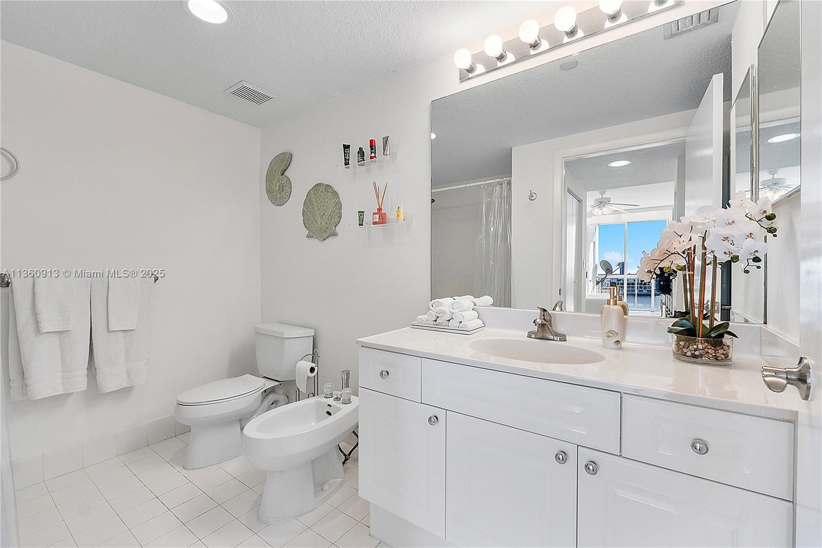 17050 North Bay Road, Unit 807 Sunny Isles Beach, FL 33160 - Photo 17 of 50 a bathroom with a sink vanity mirror and toilet