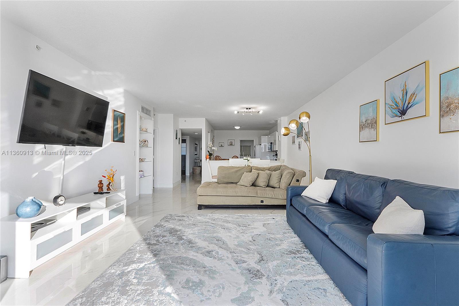 17050 North Bay Road, Unit 807 Sunny Isles Beach, FL 33160 - Photo 4 of 50 a living room with furniture and a flat screen tv