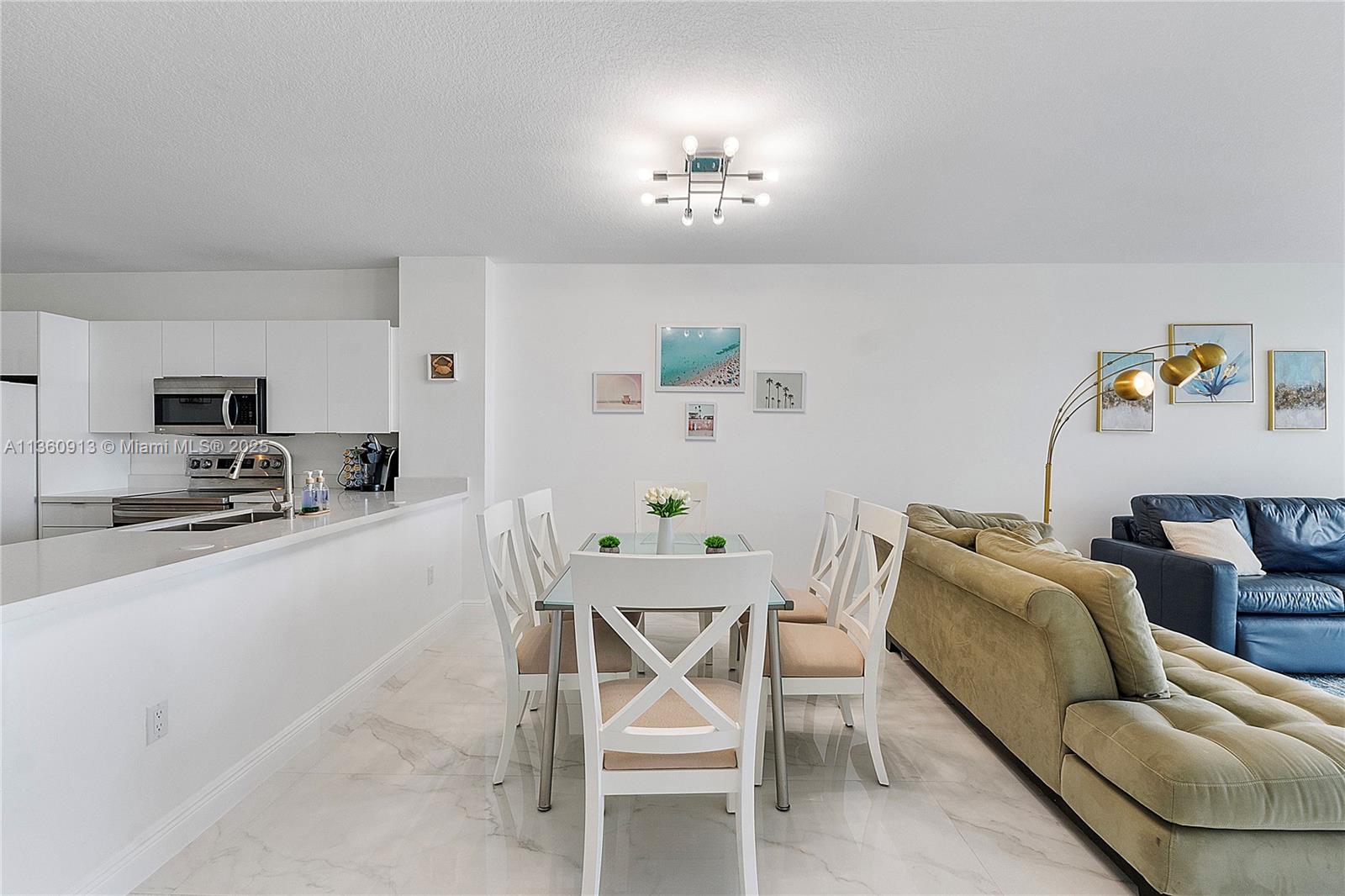 17050 North Bay Road, Unit 807 Sunny Isles Beach, FL 33160 - Photo 6 of 50 a living room with furniture and a dining table