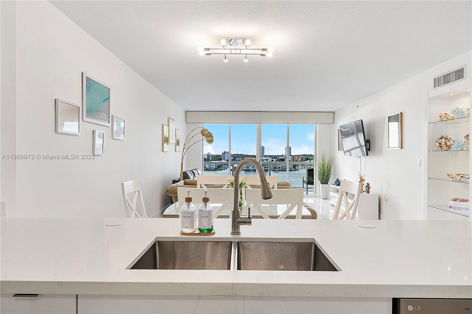 17050 North Bay Road, Unit 807 Sunny Isles Beach, FL 33160 - Photo 9 of 50 a kitchen with kitchen island a sink appliances and a counter top space