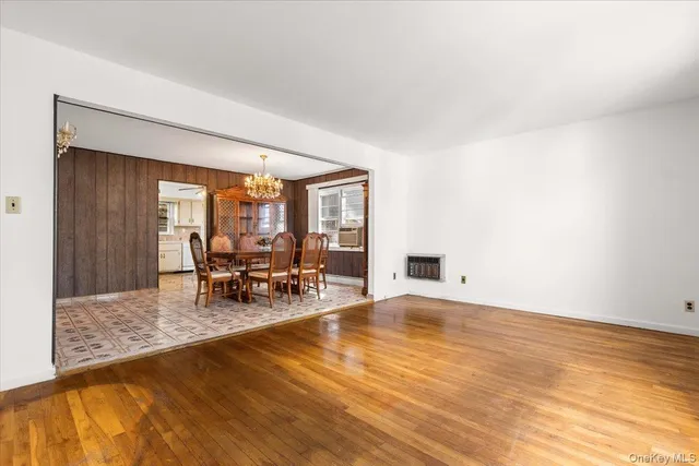 a view of a room with wooden floor table and chairs