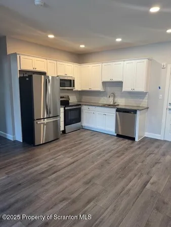 a kitchen with stainless steel appliances granite countertop a refrigerator sink and cabinets