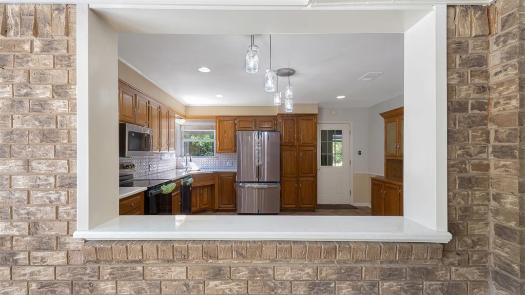 2801 Florence Street Kilgore, TX 75662 - Photo 18 of 39 a large kitchen with stainless steel appliances granite countertop a refrigerator and a stove top oven