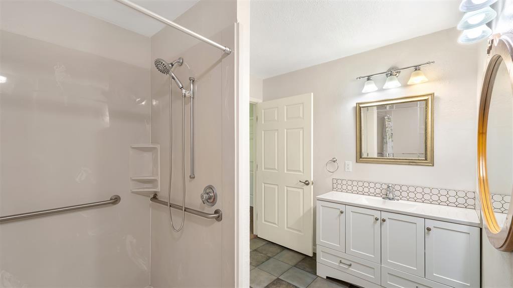 2801 Florence Street Kilgore, TX 75662 - Photo 24 of 39 a bathroom with a shower sink and mirror