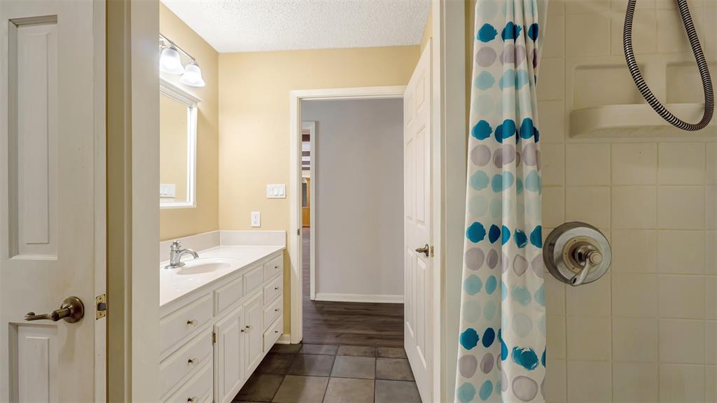 2801 Florence Street Kilgore, TX 75662 - Photo 37 of 39 a bathroom with a sink a mirror a vanity and shower