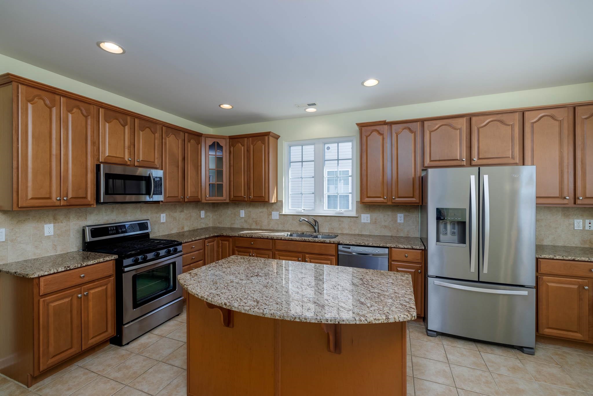 302 Aberdeen Way Rio Grande, NJ 08242 - Photo 4 of 23 a kitchen with stainless steel appliances granite countertop a refrigerator stove microwave sink and cabinets