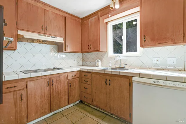 a kitchen with a sink a stove and cabinets