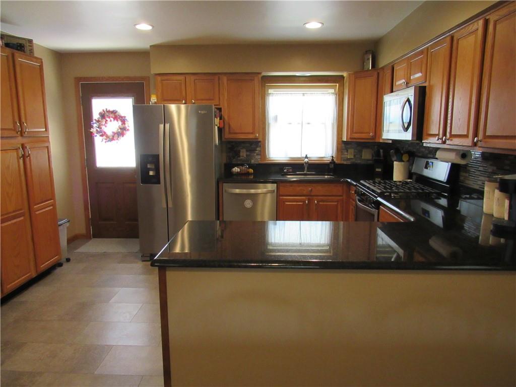 119 Eastern Drive Lower Burrell, PA 15068 - Photo 8 of 24 a kitchen with kitchen island a counter top space a sink a refrigerator and a window