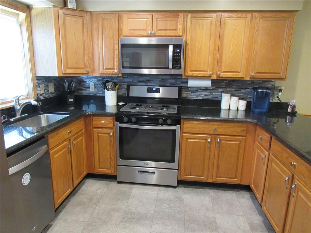 119 Eastern Drive Lower Burrell, PA 15068 - Photo 9 of 24 a kitchen with stainless steel appliances granite countertop a stove a sink and a microwave