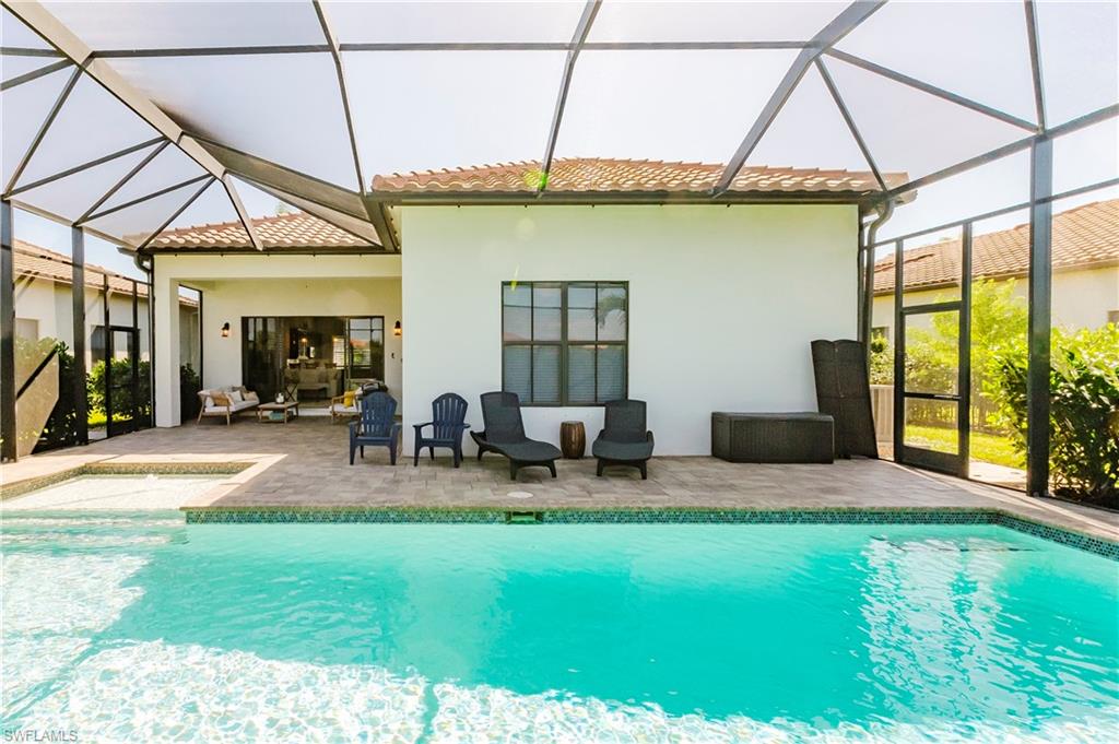 5265 Messina Street Ave Maria, FL 34142 - Photo 20 of 30 a backyard of a house with table and chairs