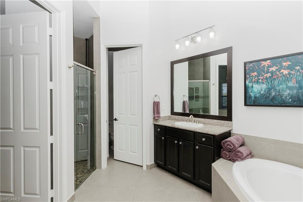5265 Messina Street Ave Maria, FL 34142 - Photo 24 of 30 a bathroom with a bathtub sink and mirror