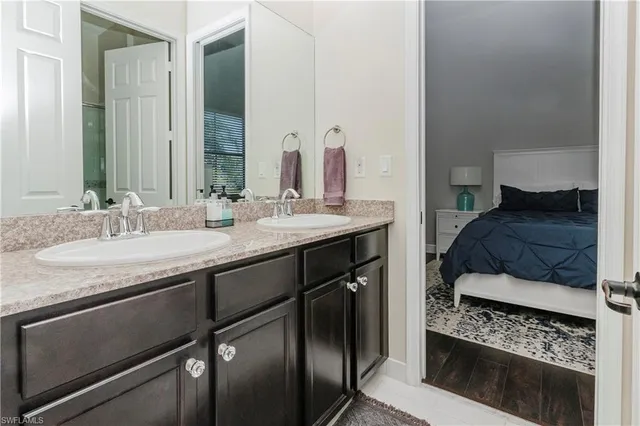 a en suite bathroom with a granite countertop sink and a mirror