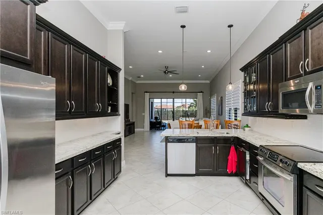 a kitchen with stainless steel appliances granite countertop a refrigerator a stove and a sink