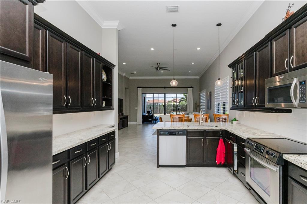 5265 Messina Street Ave Maria, FL 34142 - Photo 5 of 30 a kitchen with stainless steel appliances granite countertop a stove and a refrigerator