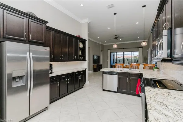 a kitchen with stainless steel appliances granite countertop a stove a sink dishwasher a microwave oven and a refrigerator with wooden cabinets