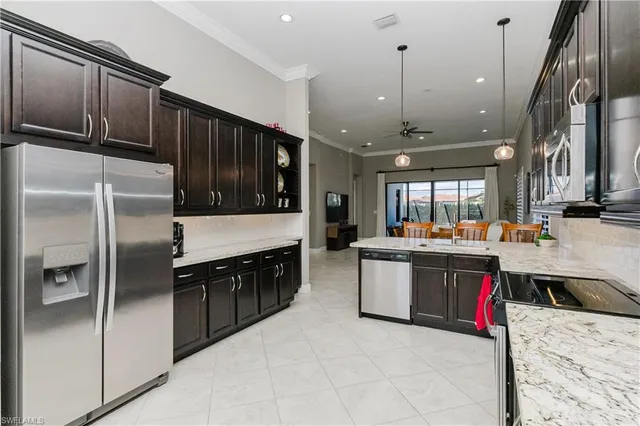 a kitchen with stainless steel appliances granite countertop a stove a sink dishwasher a microwave oven and a refrigerator with wooden cabinets