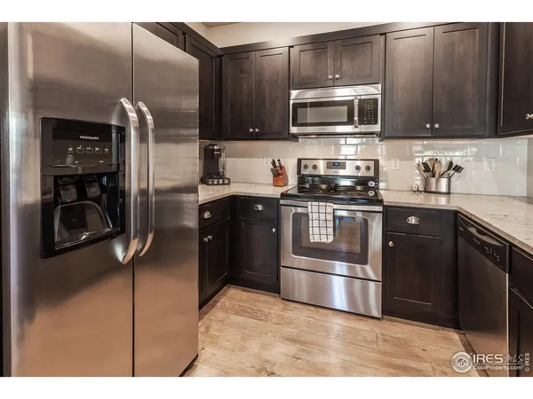 a kitchen with stainless steel appliances granite countertop a stove a microwave and a refrigerator