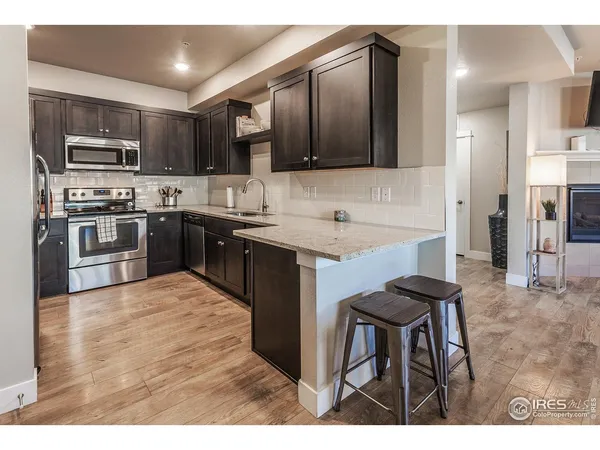 a kitchen with stainless steel appliances granite countertop a stove top oven a sink and dishwasher