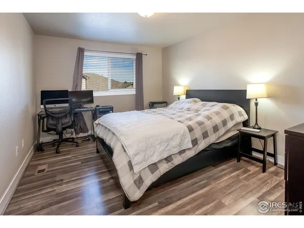 a bedroom with a bed table closet and a window