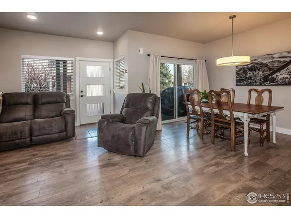 a living room with furniture a large window and a dining table