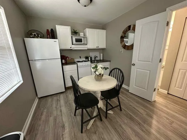 a view of kitchen with refrigerator and wooden floor