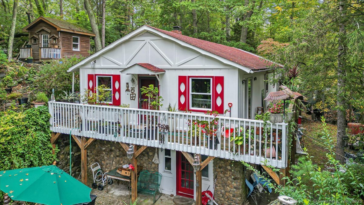 a view of small house with deck and garden