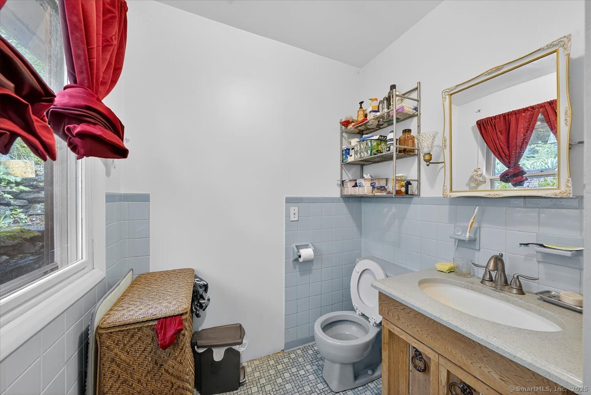 54 Mountain Road Wilton, CT 06897 - Photo 14 of 27 a bathroom with a toilet sink and mirror