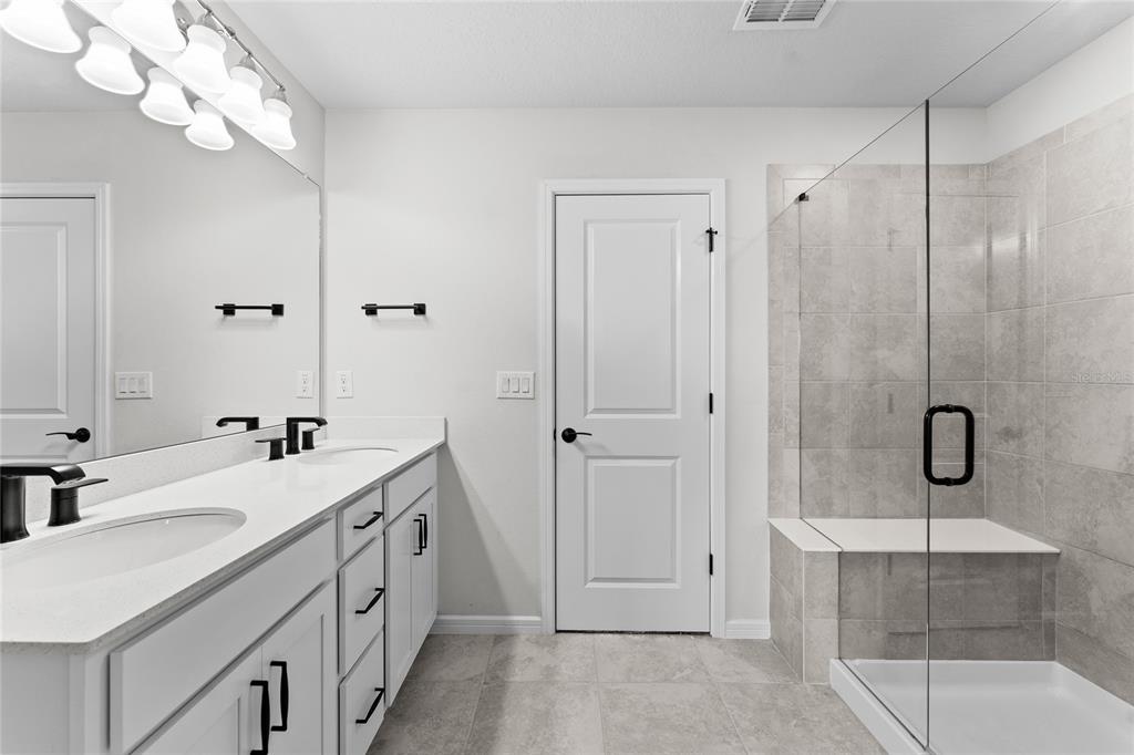 20602 Monza Loop Land O Lakes, FL 34638 - Photo 19 of 44 a spacious bathroom with a double vanity sink a large mirror and shower