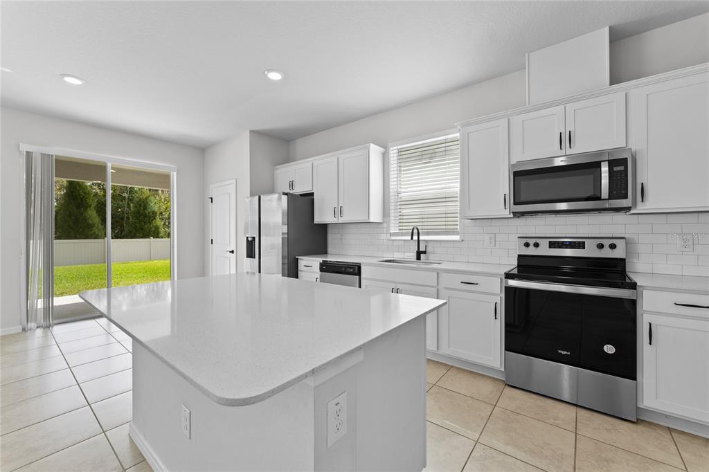 20602 Monza Loop Land O Lakes, FL 34638 - Photo 7 of 44 a kitchen with stainless steel appliances a stove sink microwave and cabinets