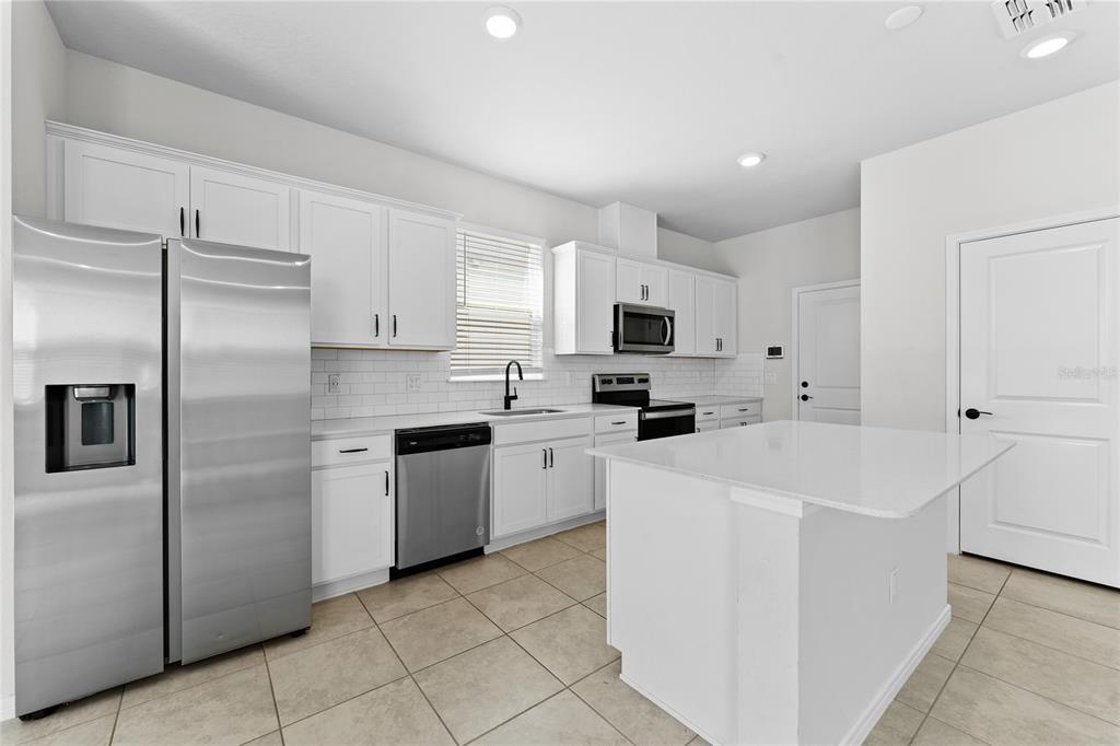 20602 Monza Loop Land O Lakes, FL 34638 - Photo 9 of 44 a kitchen with white cabinets and white appliances