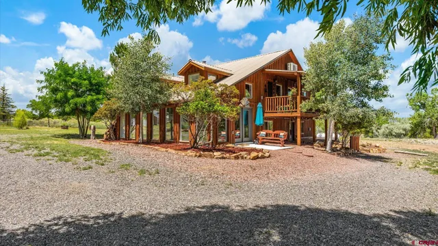 a view of a house with backyard and trees