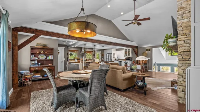 a view of a dining room with furniture a rug and wooden floor