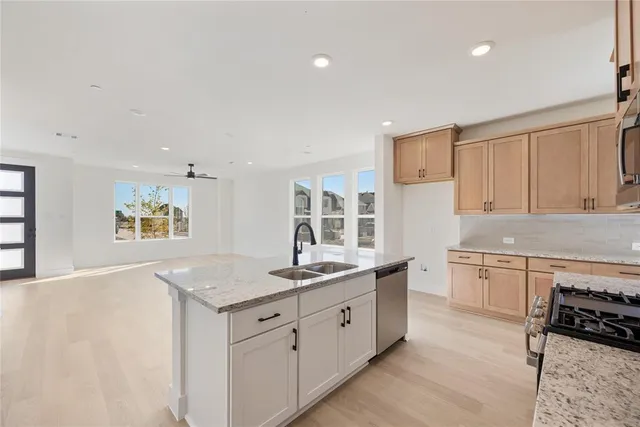 a kitchen with granite countertop a sink stove and cabinets