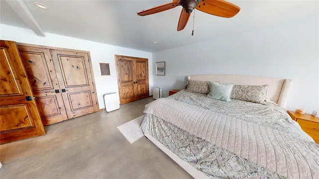 a bedroom with a bed and a ceiling fan