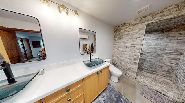 a bathroom with a granite countertop sink a toilet and mirror