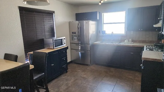 a kitchen with cabinets a window and stainless steel appliances