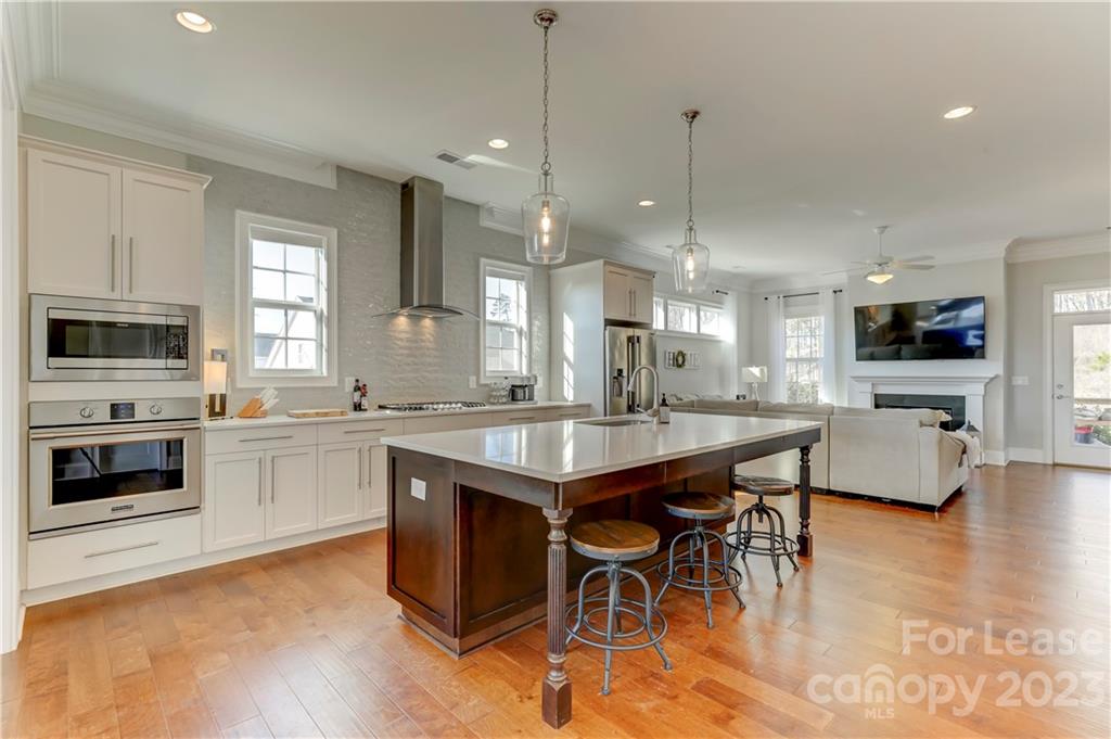 570 Crawfish Drive Fort Mill, SC 29708 - Photo 1 of 48 a kitchen with stainless steel appliances granite countertop a stove top oven a sink dishwasher a dining table and chairs with wooden floor