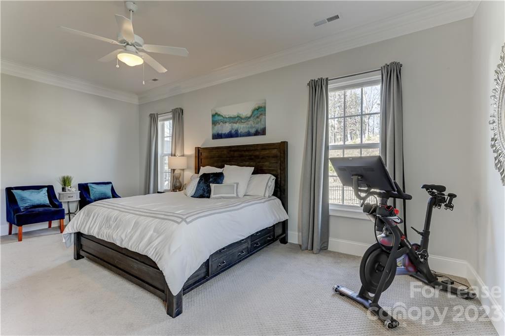 570 Crawfish Drive Fort Mill, SC 29708 - Photo 23 of 48 a bedroom with a bed gym equipment and a chandelier
