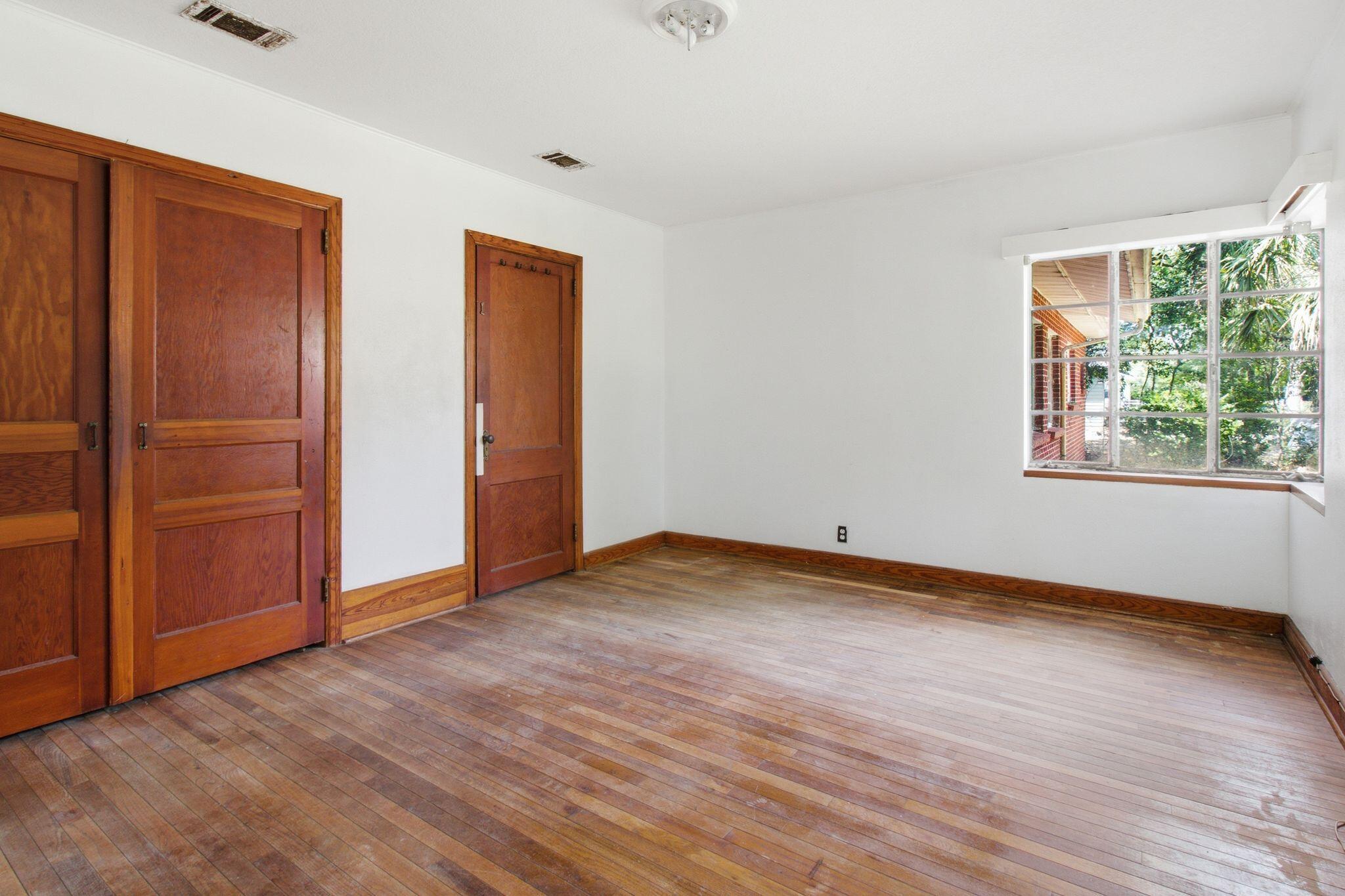 855 North Pearl Street Crestview, FL 32536 - Photo 19 of 31 an empty room with wooden floor and windows