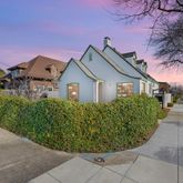a front view of a house with a yard and potted plants