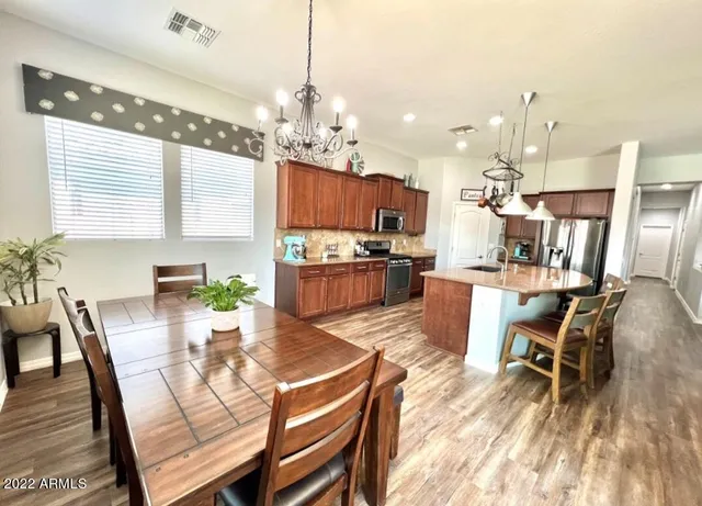 a view of a dining room with furniture a chandelier and wooden floor