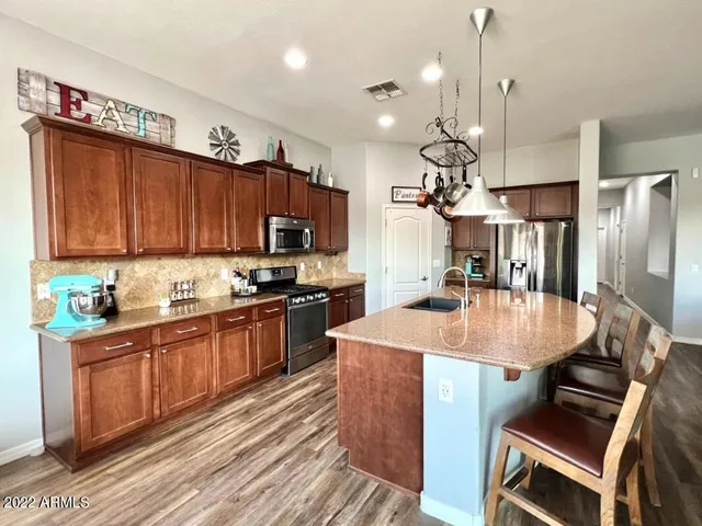 a kitchen with kitchen island a sink stove and refrigerator