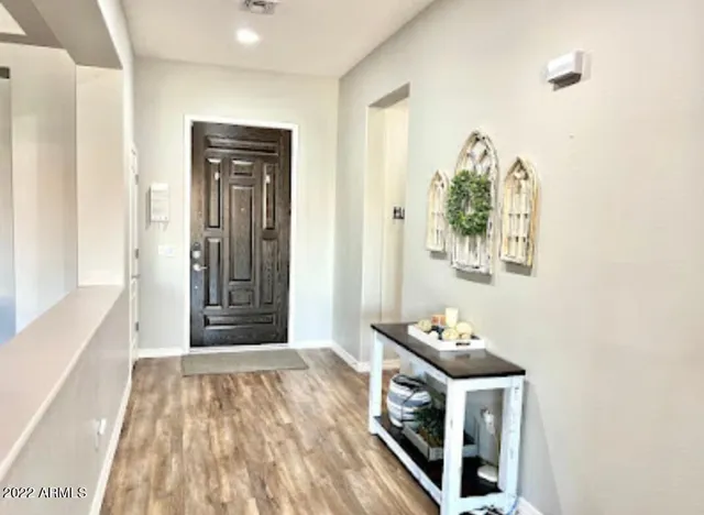 a view of a hallway with wooden floor and a bathroom